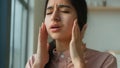 Tired sick woman arabian indian girl near window at home suffer from headache touch painful head migraine pain unhealthy Royalty Free Stock Photo