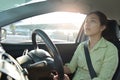 Tired Sleepy Asian Business woman driving a car.