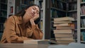 Tired sleepy asian woman student fall asleep in university library exhausted drowsy girl sleeping on desk with stack Royalty Free Stock Photo