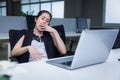 Tired sleepy asian woman yawning working at office desk. overwork and sleep deprivation concept Royalty Free Stock Photo