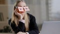 Tired sleepy caucasian woman with adhesive notes on eyes sticky notes on glasses. Lazy exhausted female sit at desk feel