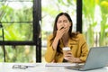 Tired and sleepy company employee holds a coffee cup in the office