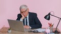 Tired sleepy overworked senior business man falling asleep sit at office desk with laptop Royalty Free Stock Photo