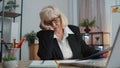 Tired sleepy overworked senior business woman falling asleep sit at home office desk with laptop Royalty Free Stock Photo