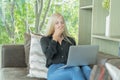 Tired sleepy western business woman yawning and working from home with computer laptop notebook on sofa in living room at home. Royalty Free Stock Photo