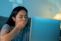 Tired and sleepy woman working in front of laptop at home. Tired woman is yawning and working laptop overtime late night Royalty Free Stock Photo