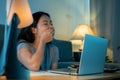 Tired and sleepy woman working in front of laptop at home. Tired woman is yawning and working laptop overtime late night Royalty Free Stock Photo