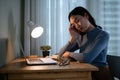 A tired Asian female college student is falling asleep at a table in her room in the evening Royalty Free Stock Photo