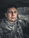 A tired soldier of the Ukrainian army sits in a car and looks into the camera