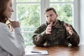 Tired soldier with war syndrome talking with therapist during meeting in the office