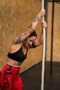 Tired sportive woman climbing a rope in a gym Royalty Free Stock Photo
