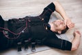 Tired sportsman lying on floor after training with ems