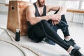 Tired sportsman relaxing on wooden box in fitness gym Royalty Free Stock Photo