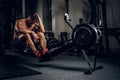 Tired sporty male after workouts on power exercise machine. Royalty Free Stock Photo