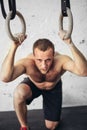 Tired sporty male after workouts on rings in a gym club Royalty Free Stock Photo