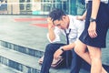 Tired or stressed businessman sitting on the walkway after work