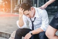 Tired or stressed businessman sitting on the walkway after work