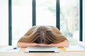 Tired and stressed woman with head down in front of laptop