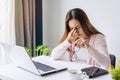 Tired and stressed young asian woman feel pain eyestrain and rubbing her eyes and take off her glasses while sitting at her Royalty Free Stock Photo