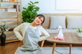 Tired stressed young Asian woman with headache doing spring cleaning chores in her living room at home overworked housekeeping Royalty Free Stock Photo