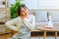 Tired stressed young Asian woman with headache doing spring cleaning chores in her living room at home overworked housekeeping Royalty Free Stock Photo