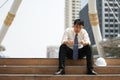 Tired or stressful businessman sit on the stairs after working