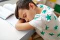 Tired student boy sleeping on table at home Royalty Free Stock Photo