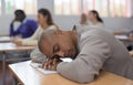 Tired student fell asleep in lesson in university classroom