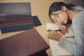 Tired student girl with glasses lying on books in library Royalty Free Stock Photo