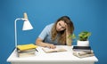 Tired student having a lot of work in a library. Too much work tired sleepy young woman sitting at her desk with books Royalty Free Stock Photo