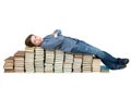 A tired student lying on a stack of books Royalty Free Stock Photo