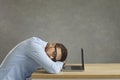 Tired student or office worker sleeping sitting at work desk near laptop computer Royalty Free Stock Photo