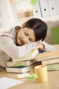 Tired student resting on pile of books