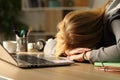 Tired student sleeping over desk at home in the night Royalty Free Stock Photo