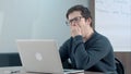 Tired student thinking about his work and using laptop Royalty Free Stock Photo