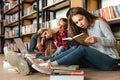 Tired students sitting in library on floor reading books Royalty Free Stock Photo