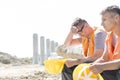 Tired supervisor sitting with colleague at construction site Royalty Free Stock Photo