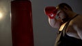 Tired sweaty boxer punching bag in gloves, sport lifestyle, health care, diet