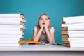 Tired teen girl with books on the background of a school board looking at camera. Space for text