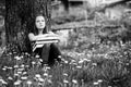 Tired teen girl with books in the park. Black and white photo. Royalty Free Stock Photo