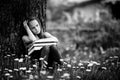 Tired teen girl with books in the park. Black and white photo. Royalty Free Stock Photo