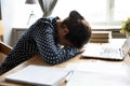 Tired indian girl student sleeping at desk exhausted after learning