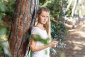 Tired teen girl using phone at bridge in summer green park