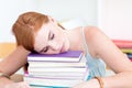 Tired teen sleeping on books after studying