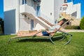 Tired teenager student asleep on sunbed with book