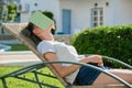 Tired teenager student asleep on sunbed with book