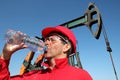 Tired and Thirsty Oil Worker at Oil Field In Desert