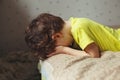 Tired toddler boy lying on the bed with his face down. Crying little kid Royalty Free Stock Photo