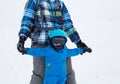 Tired toddler boy in warm blue overalls learns to ski with daddy Royalty Free Stock Photo