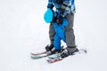 Tired toddler boy in warm blue overalls learns to ski with his dad Royalty Free Stock Photo